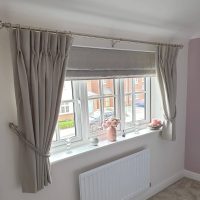 pale grey Roman blinds with matching curtains