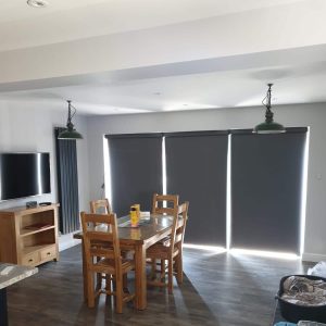 closed grey electric roller blinds on bi-fold doors