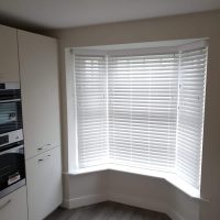 closed white Venetian blinds in a kitchen