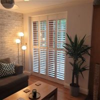 open full height shutters on a patio door in living room