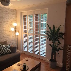 open full height shutters on a patio door in living room