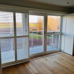 half open large tracked shutters in front of a balcony