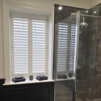 white plantation shutters in modern bathroom
