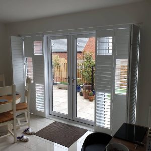 partly open white tracked shutters