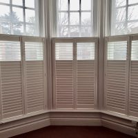 white cafe style shutters on a sash window