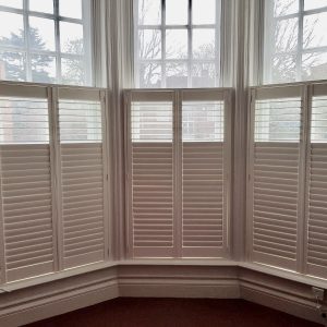 white cafe style shutters on a sash window