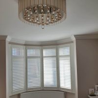 white plantation shutters in a curved bay window