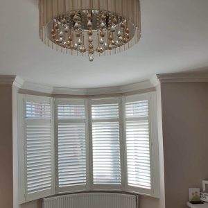 white plantation shutters in a curved bay window