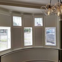 white plantation shutters, half opened, half closed