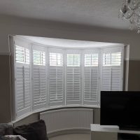 white plantation shutters on a large bay window
