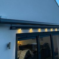 Electric Awning with lighting above screen door to at rear of property