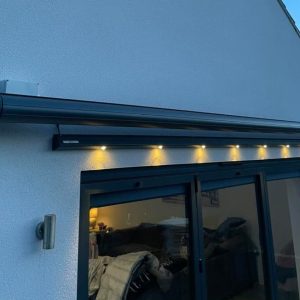 Electric Awning with lighting above screen door to at rear of property