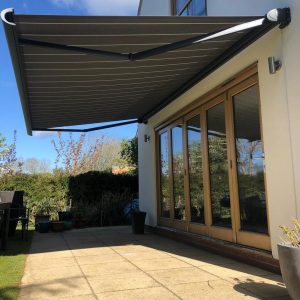 electric awnings from a side angle as a covering sliding doors at side of house